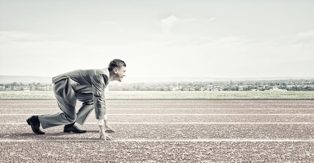 Young businessman standing in start pose ready to run